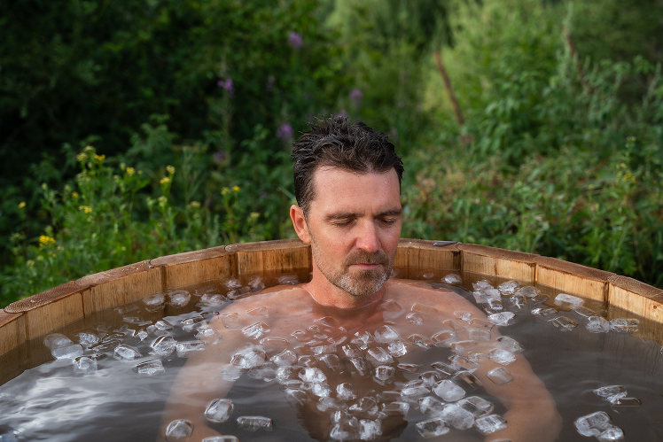 Mikkem practicing ice bathing in a wooden tub during the retreat