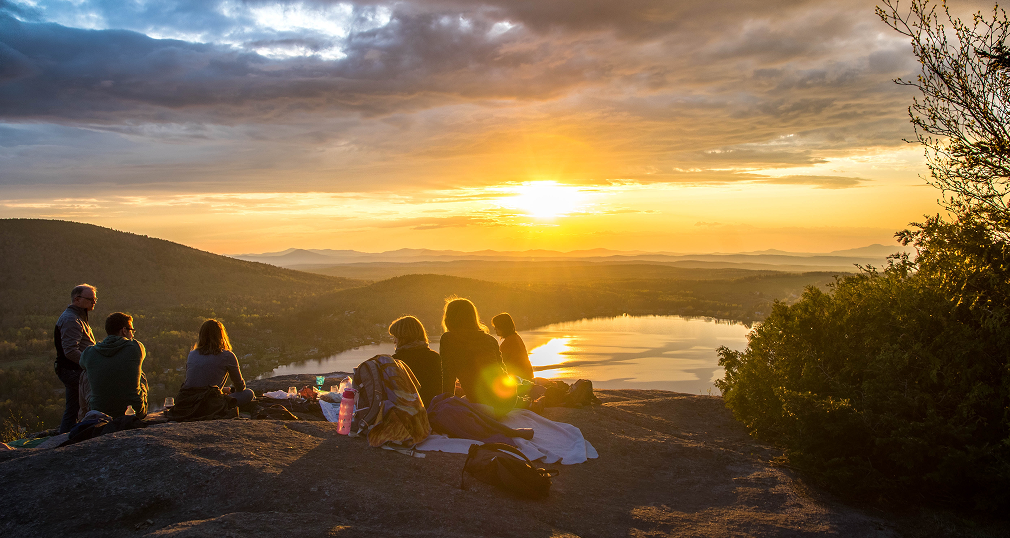 Group watching the sunset over the mountains and lake during the Regenerative Business Compass Retreat